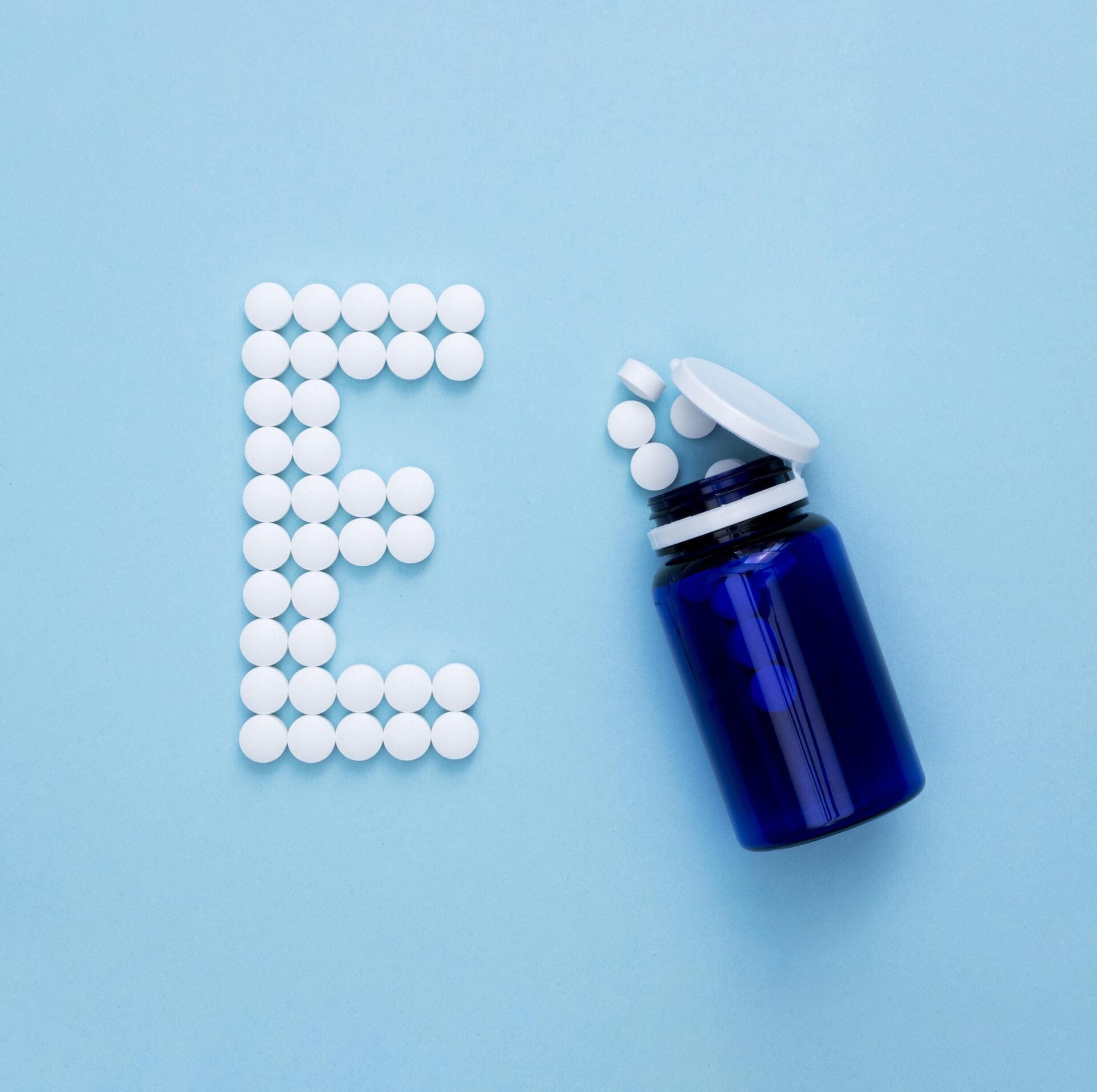 flat-lay-container-with-pills-spelling-letter-e2